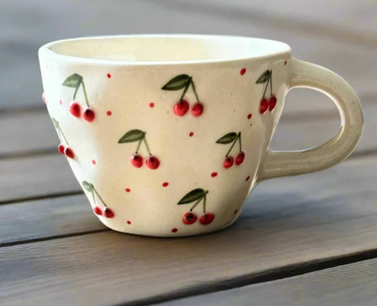 Ceramic mug with cherry design on a wooden surface